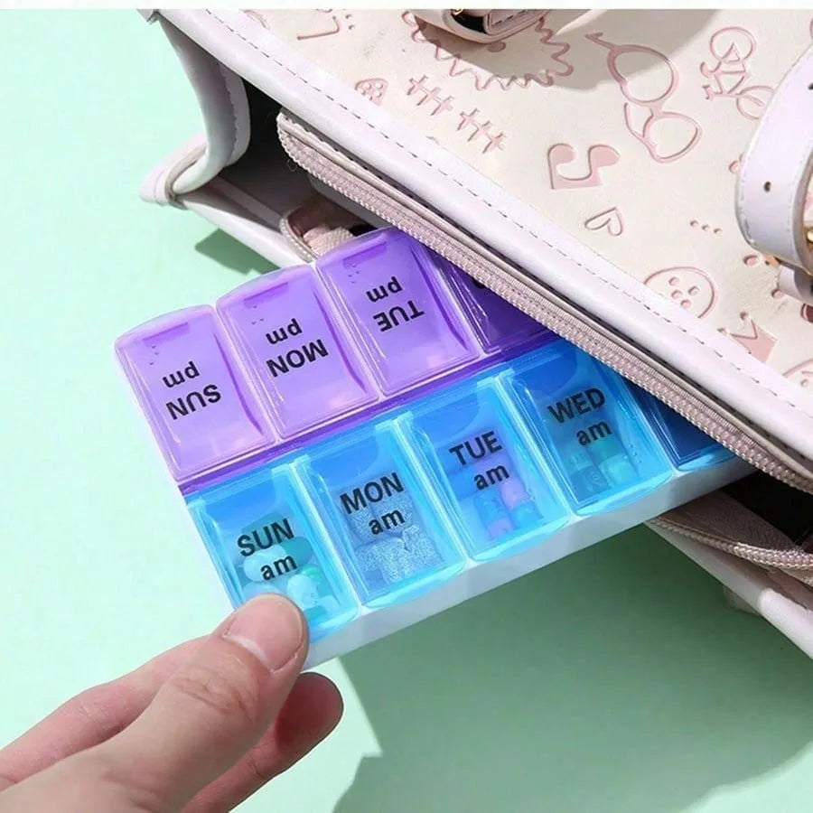 A hand is pulling out a weekly pill organizer tray from a light pink patterned handbag. The pill organizer has a purple-to-blue translucent color gradient and is labeled with days of the week (SUN pm through WED am).
